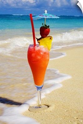 A tropical cocktail on the beach, wave washing on the sand.