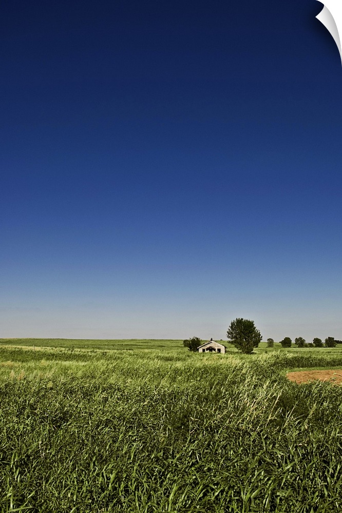 A long-abandoned house sits in a field in the desolate grassy plains of southwest Oklahoma.