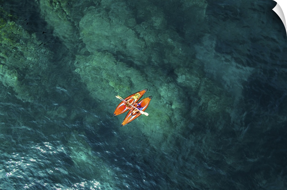 Aerial picture of two girls practicing kayak in a paradise place of the costa brava beach with beautiful and transparent b...
