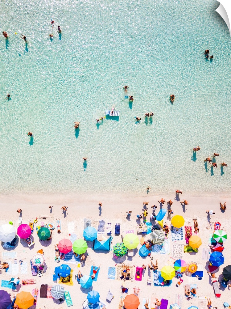 Aerial view of a white beach full of colored beach umbrellas and relaxed people swimming on a clear sea. Cala Brandinchi, ...