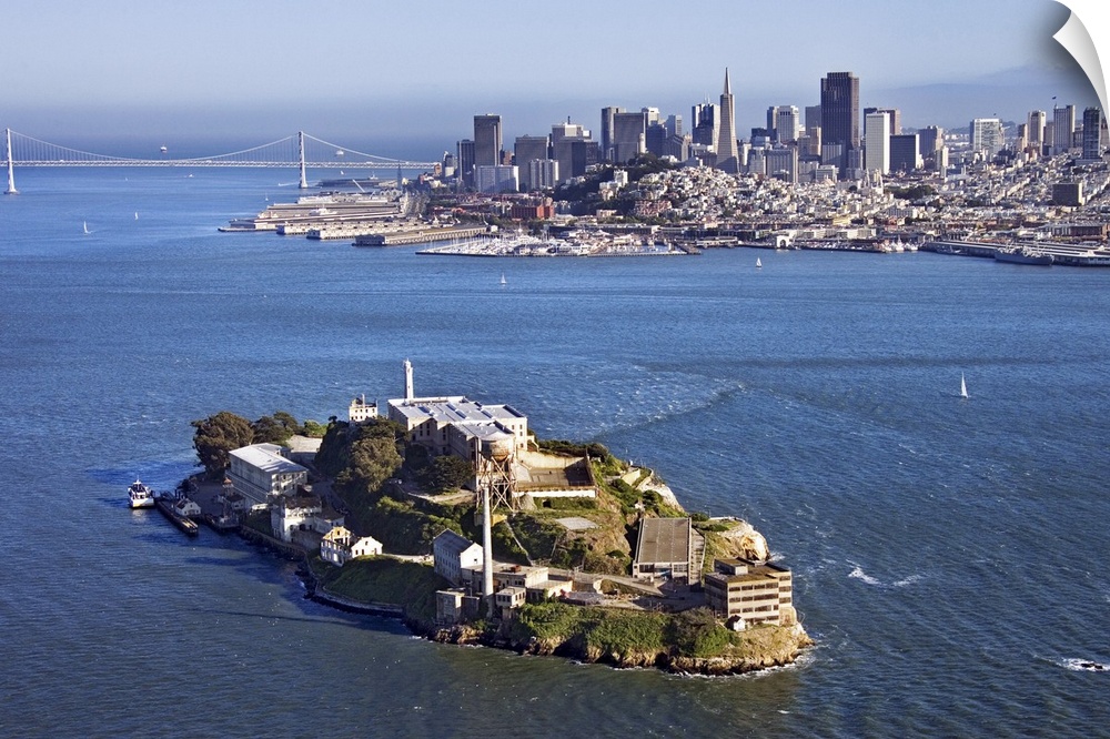 Photograph taken from high above Alcatraz on a sunny day with the city skyline and bridge in the background.