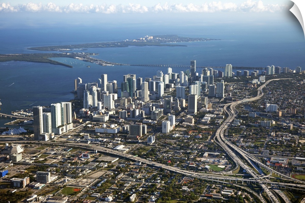 Photograph taken from above the city of Miami with the skyscrapers to the left and near the water with major highways cutt...
