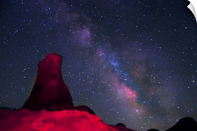 Alabama Hills, rock tower painted with red light with stars and Milky way in sky