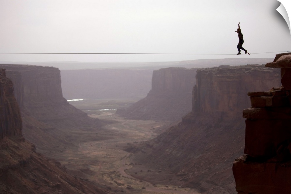 Andy Lewis working on a world record highline, three hundred and forty feet long, at the Fruit Bowl in Moab, Utah, USA.