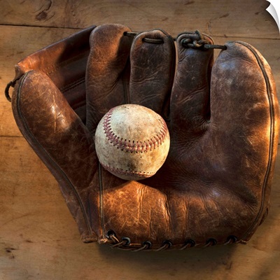 Antique baseball on baseball glove with bat