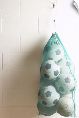 Bag of soccer balls hanging on hook