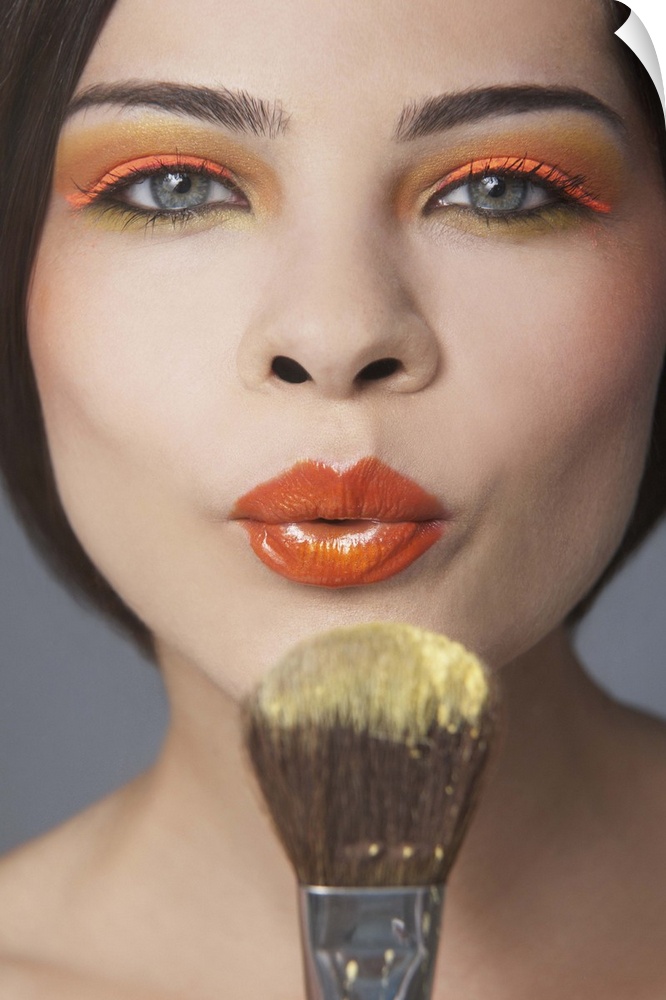 Woman blowing at make up brush