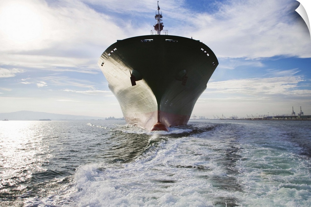 Bow view of cargo ship sailing out of port.