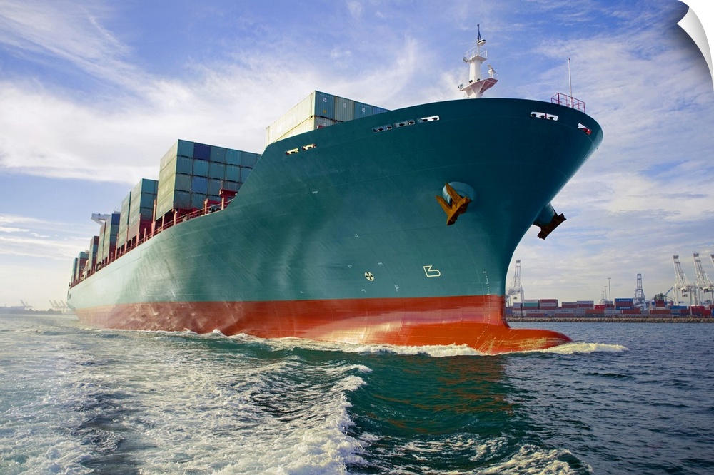 This oversized photograph is taken while looking up at a large cargo ship that is headed out to sea.