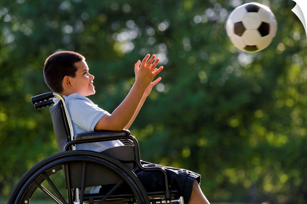 Hispanic boy, 8, in wheelchair with soccer ball