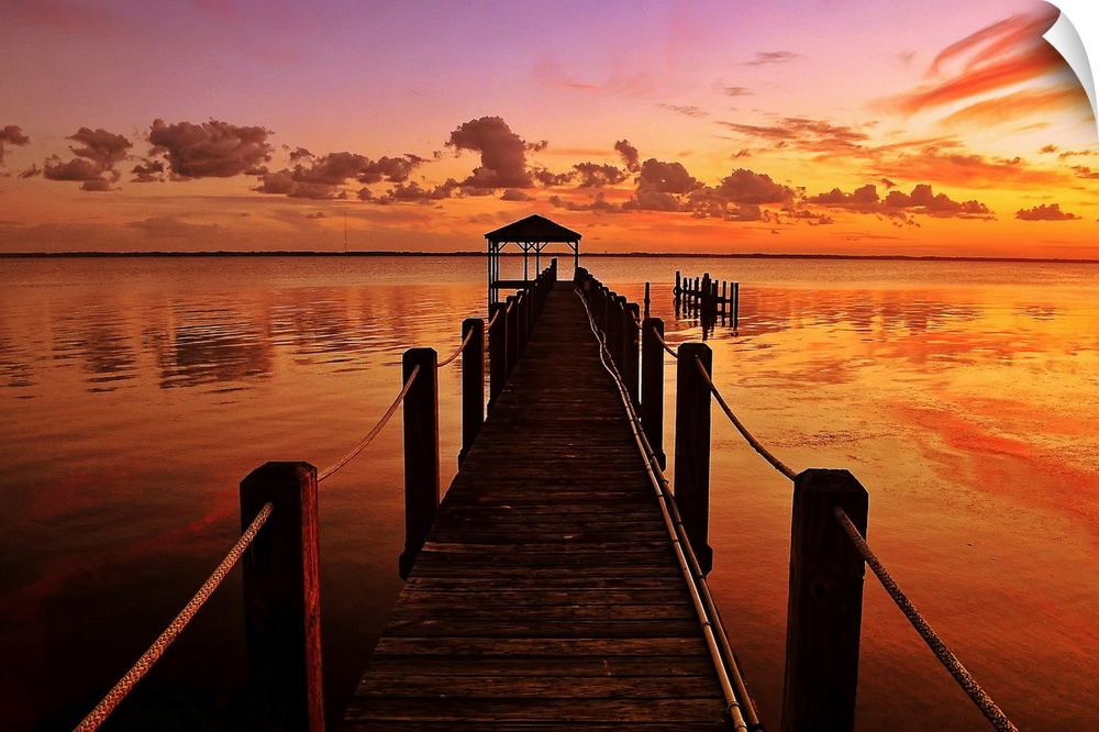 This photograph is a gorgeous landscape of a narrow dock in the Currituck Sound at sunset in the northern part of the Oute...