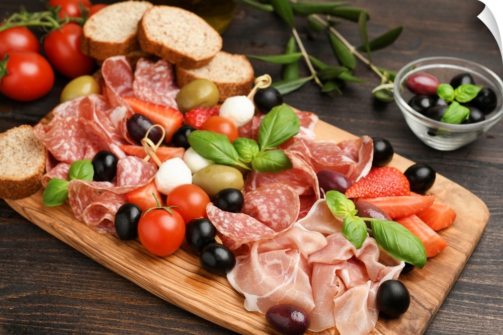 Charcuterie board salami, prosciutto, with green and black olives, appetizers with mozzarella balls, cherry tomatoes, and ...