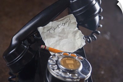 close-up of antique telephone with pencil and 'to do' list