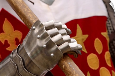 Close-up of articulated hand of armor gripping weapon