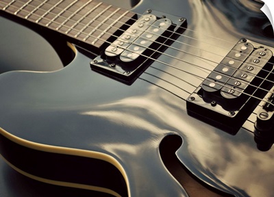 Close up shot of black guitar.