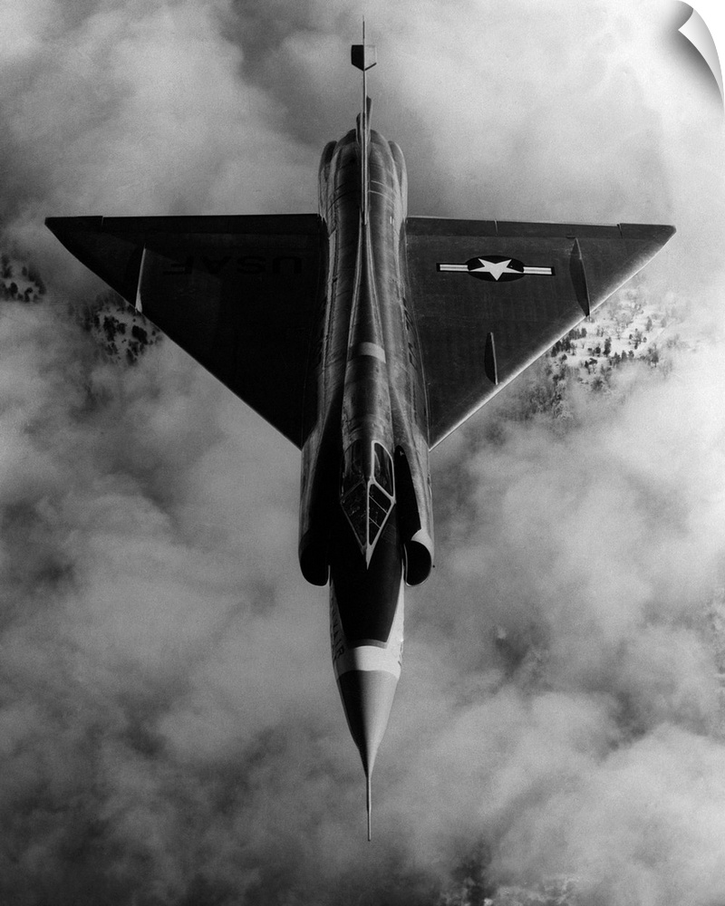A United States Air Force, delta-wing F-102A, interceptor aircraft in flight above cloud cover.