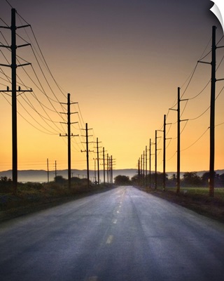 Desert road and power lines at sunset in California desert.