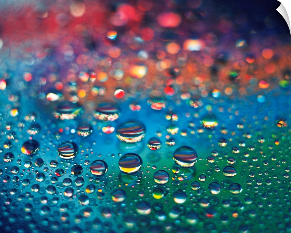 Landscape, close up photograph of dew drops of various sizes on a rainbow colored surface, using differential focus, in fo...