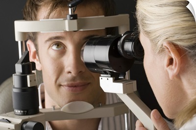 Doctor looking at eye with slit lamp