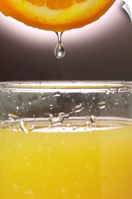 Droplet of orange going into juice