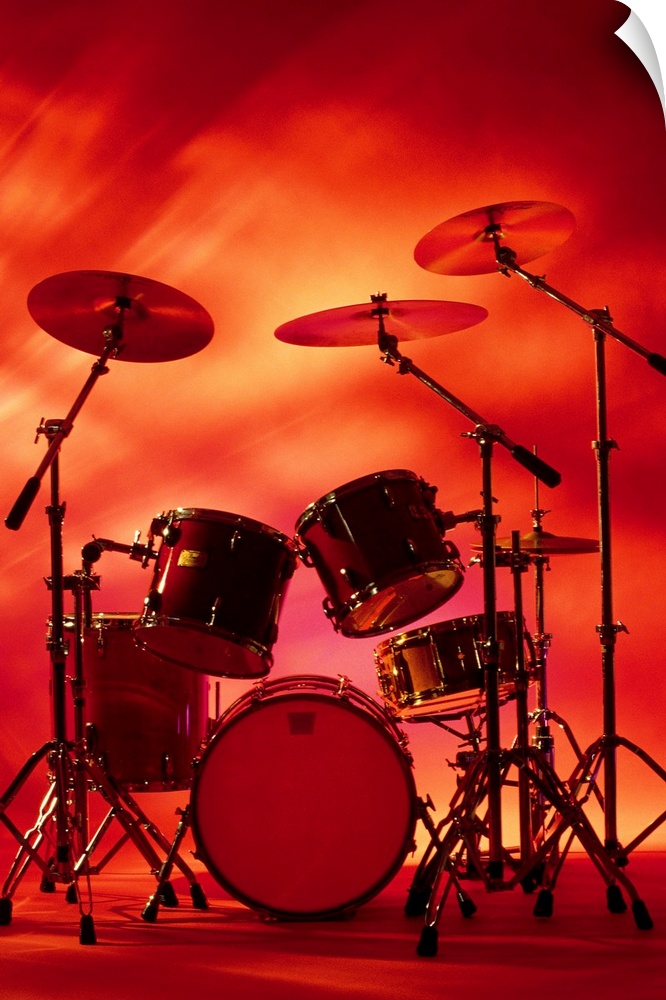 Large vertical photograph of a drum set with symbols, surrounded by warm, fiery lighting.