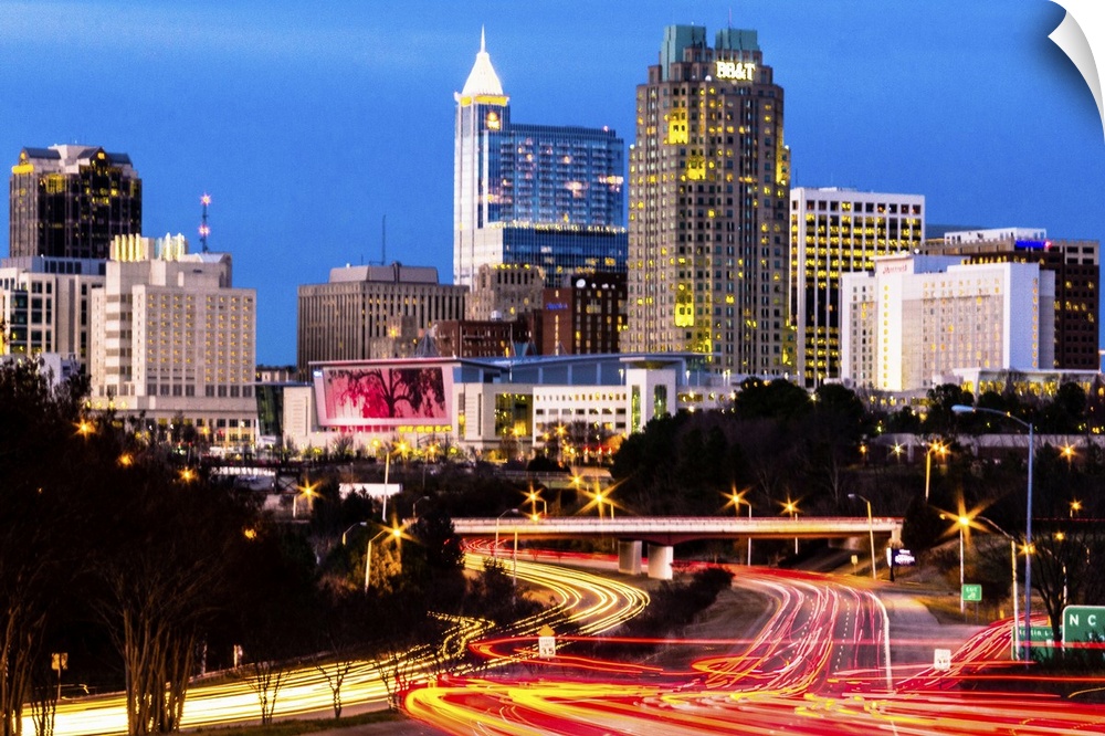Blue hour in downtown Raleigh, North Carolina, with light trails of traffic in the foreground and skyscrapers in the backg...