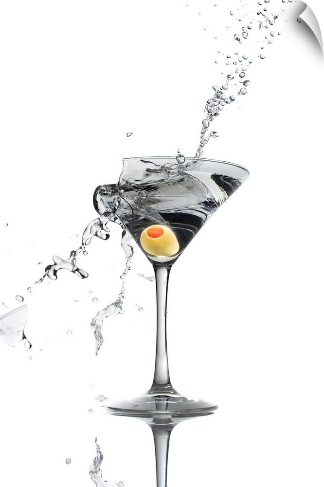 A shattering martini glass on a white background spraying liquid outward.