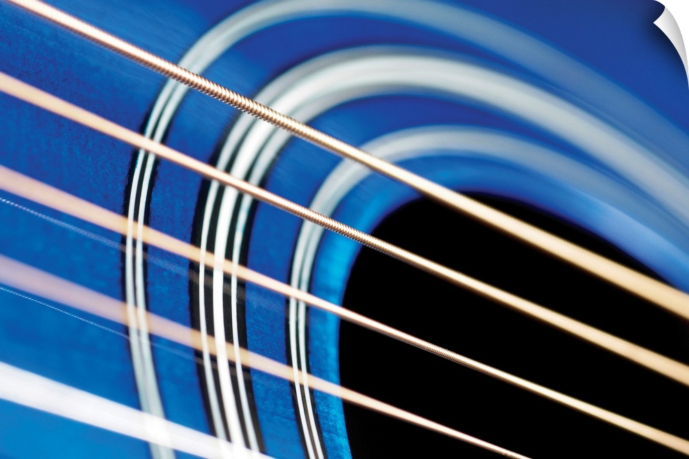 A very close view of guitar strings over the sound hole.