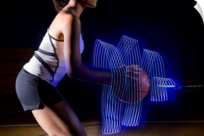 Female basketball player holding ball with surrounding light trai