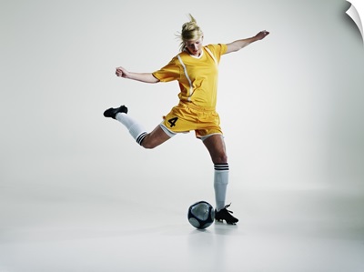 Female soccer player preparing to kick soccer ball