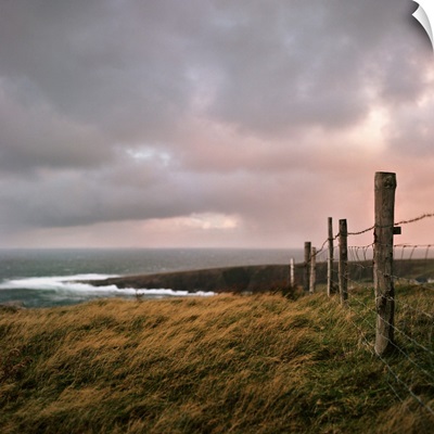 Fence stretches toward bloody foreland at sunrise in County Donegal, Ireland.