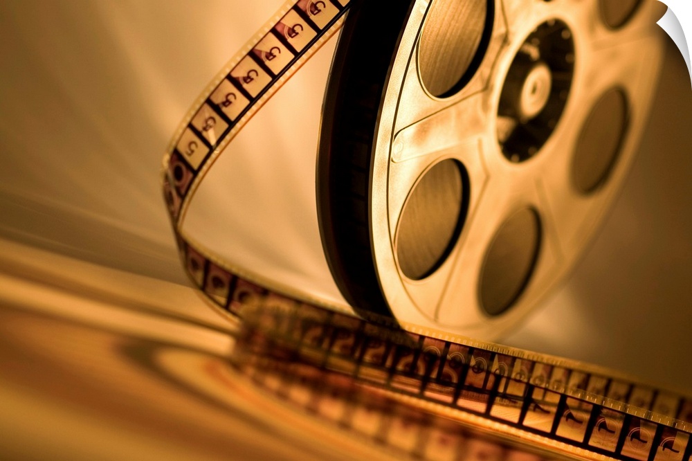 Landscape, large wall picture of a film reel sitting upright with unraveling film that curls toward the foreground.