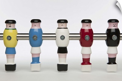Five foosball figurines wearing different uniforms