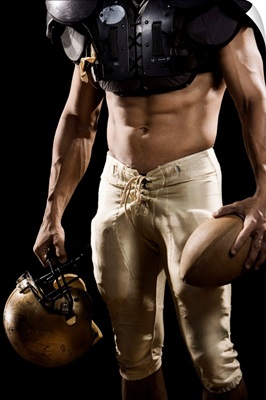 Football player with protective gear, football, and helmet