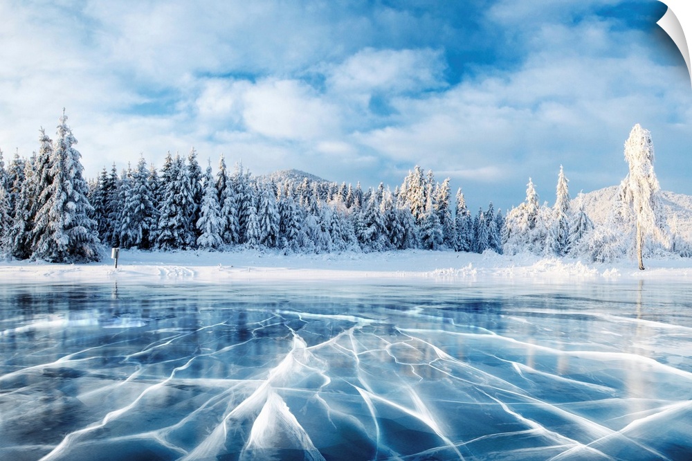Blue ice and cracks on a frozen lake under a blue sky in the winter in Carpathian, Ukraine.