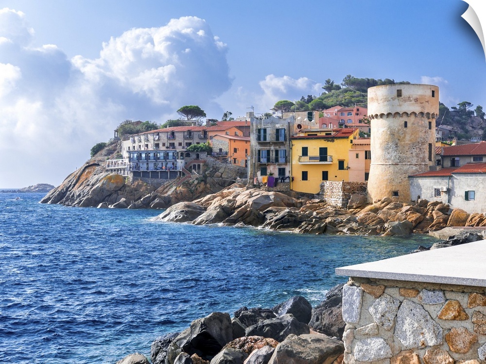 The perfect tiny seaside village of "Giglio Porto" with multi colored houses, an ancient defensive tower and a rocky coast...