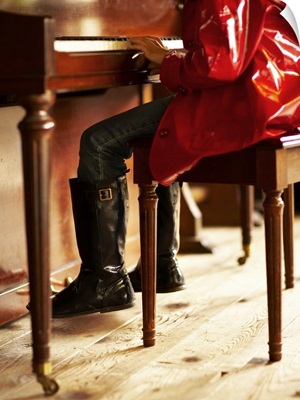 Girl in red raincoat playing piano