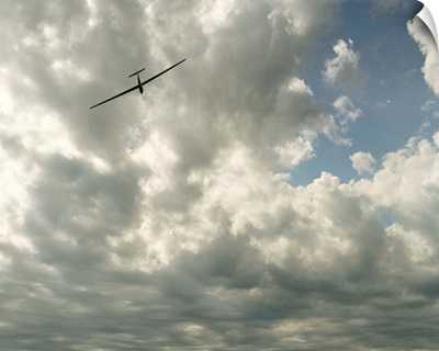 Glider in flight against cloudy sky, low angle view