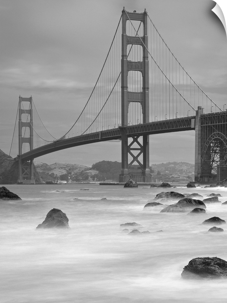 Photo on canvas of the Golden Gate Bridge with wave breaking through rocks in the water.