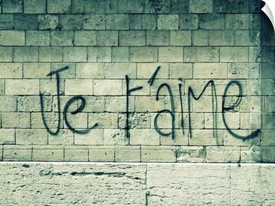 Graffiti on a wall in Paris reads 'Je t'aime' or 'I love you' in English.