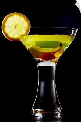 Green coloured cocktail with cherry and orange slice, close-up