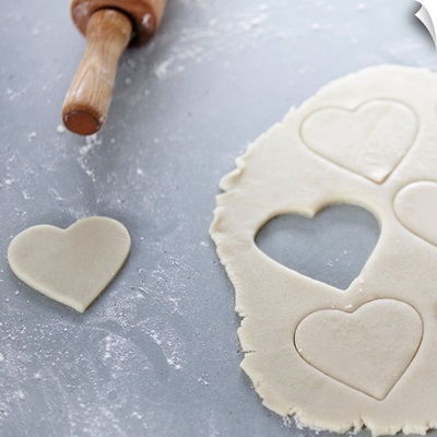 Heart shape cut out of a sheet of rolled out cookie dough