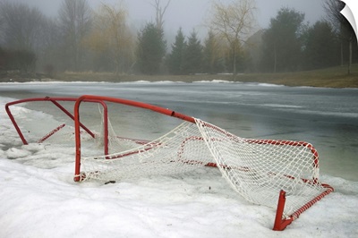 Hockey net left from season in melting snow at Ottawa, Ontario, Canada.