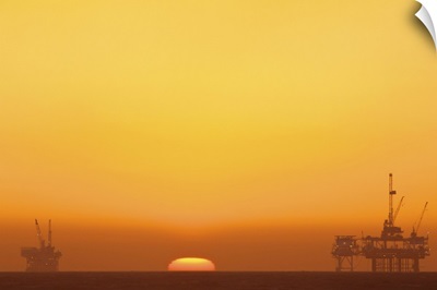 Huntington beach with oil rig during sunset.