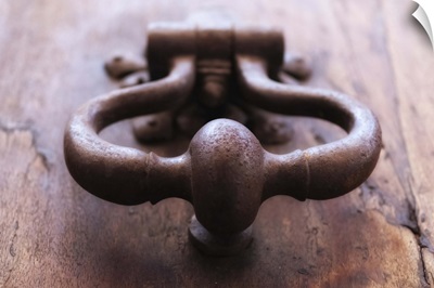 Iron door knocker on wooden door.