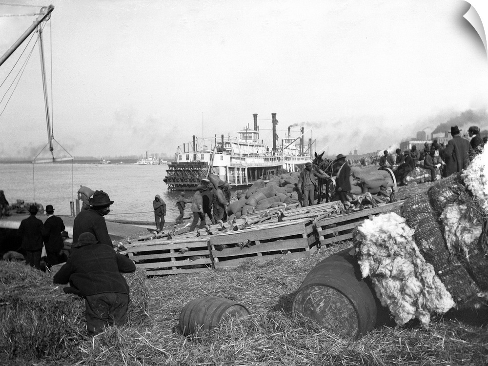 Workers load cotton and other freight on a quay in Memphis.