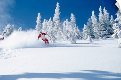 Lone skier riding through powder, British Columbia, Canada
