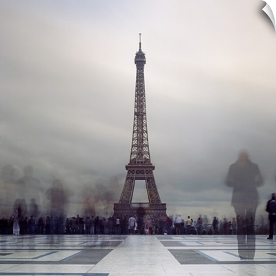 Long exposure of Eiffel Tower with figures in crowds blur in Paris.