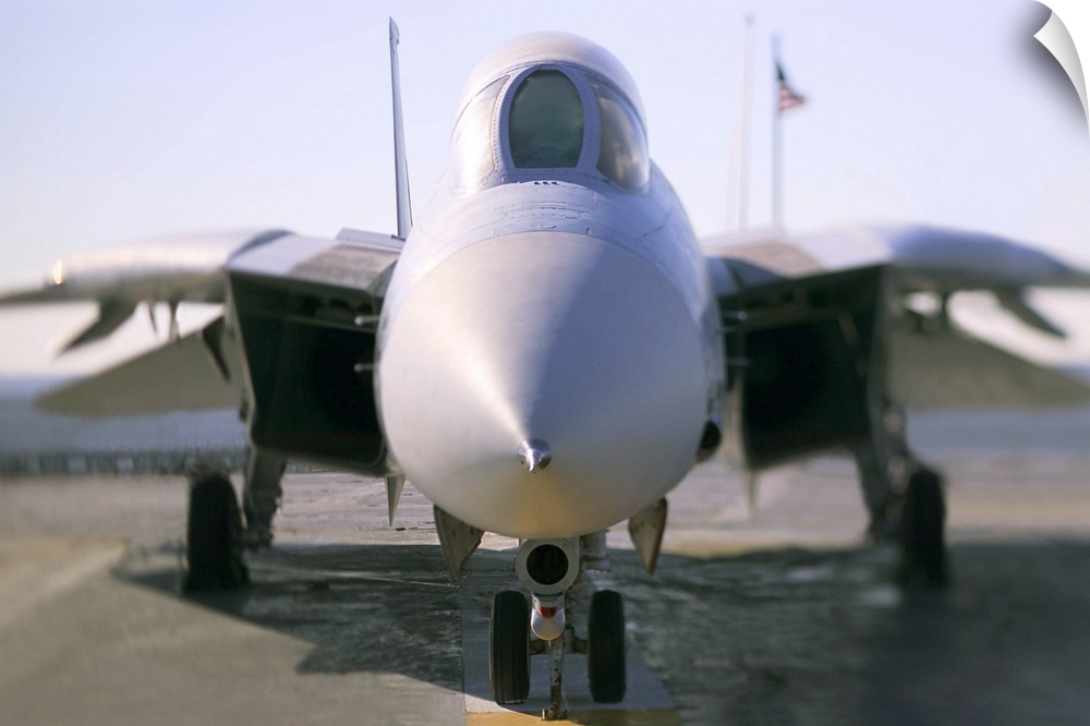 Looking straight on at the nose of an F-14 military aircraft at the airport.