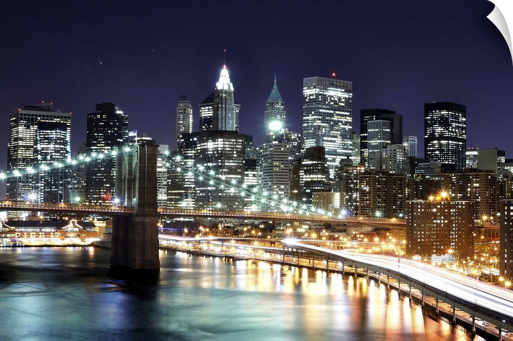 Aerial view of lower Manhattan including the financial district and the Brooklyn Bridge at night.